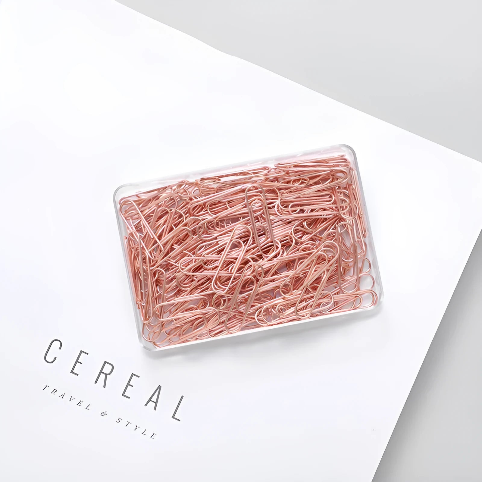 100 rose gold coloured heart-shaped metal paper clips in a box.