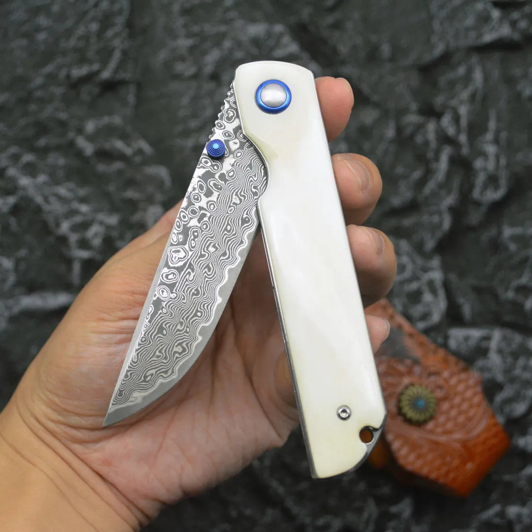 Damascus steel folding knife with black finish and ox bone handle, blade open showing 8.5cm cutting edge