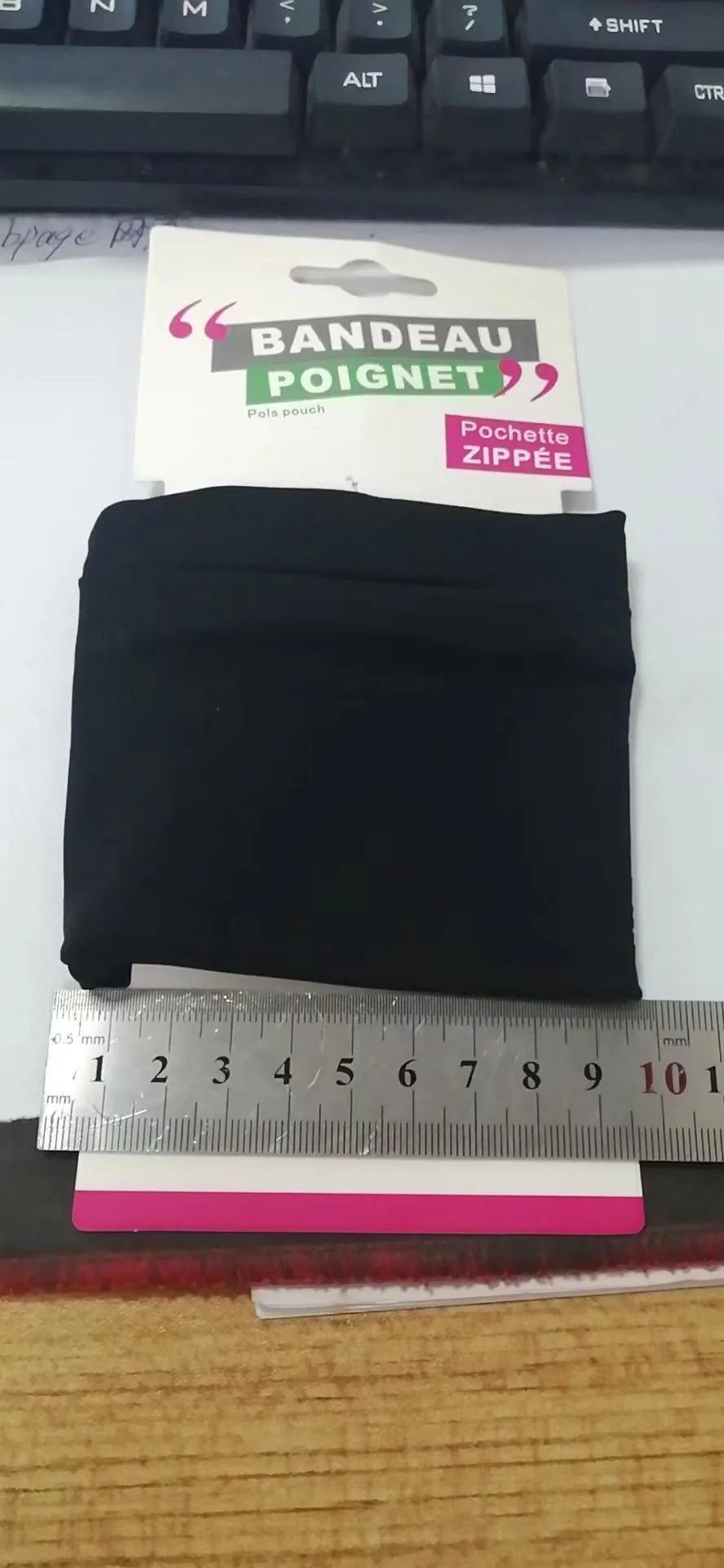 Adjustable strap wrist pouch for mobile phone, shown in packaging, dimensions 10cm by 10.5cm.