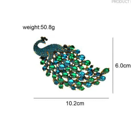 Colourful metal peacock brooch in red, green, and blue with rhinestone accents on a white background