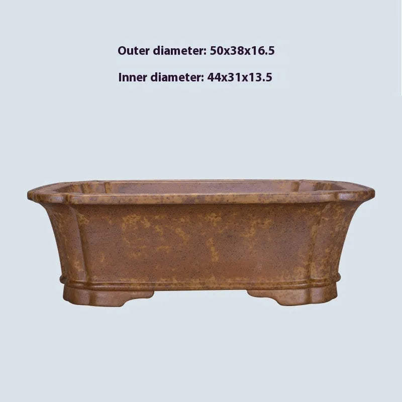 Hand-thrown rectangular purple sand flower pot with dual drainage holes on a wooden deck.