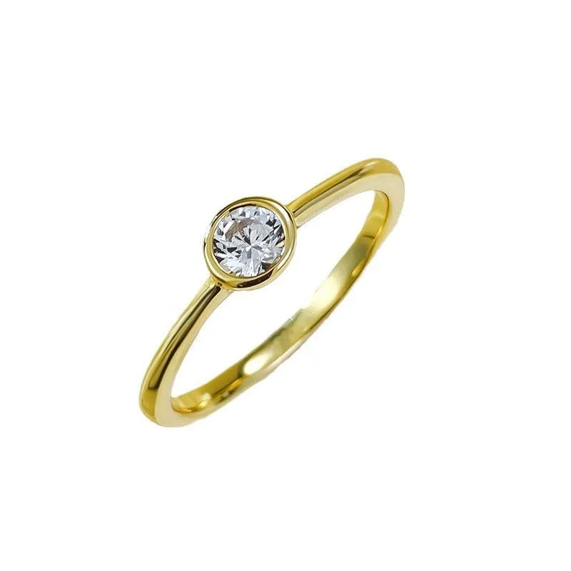 Minimalist crown-shaped silver ring in gold or platinum finish, shown in a simple setting.