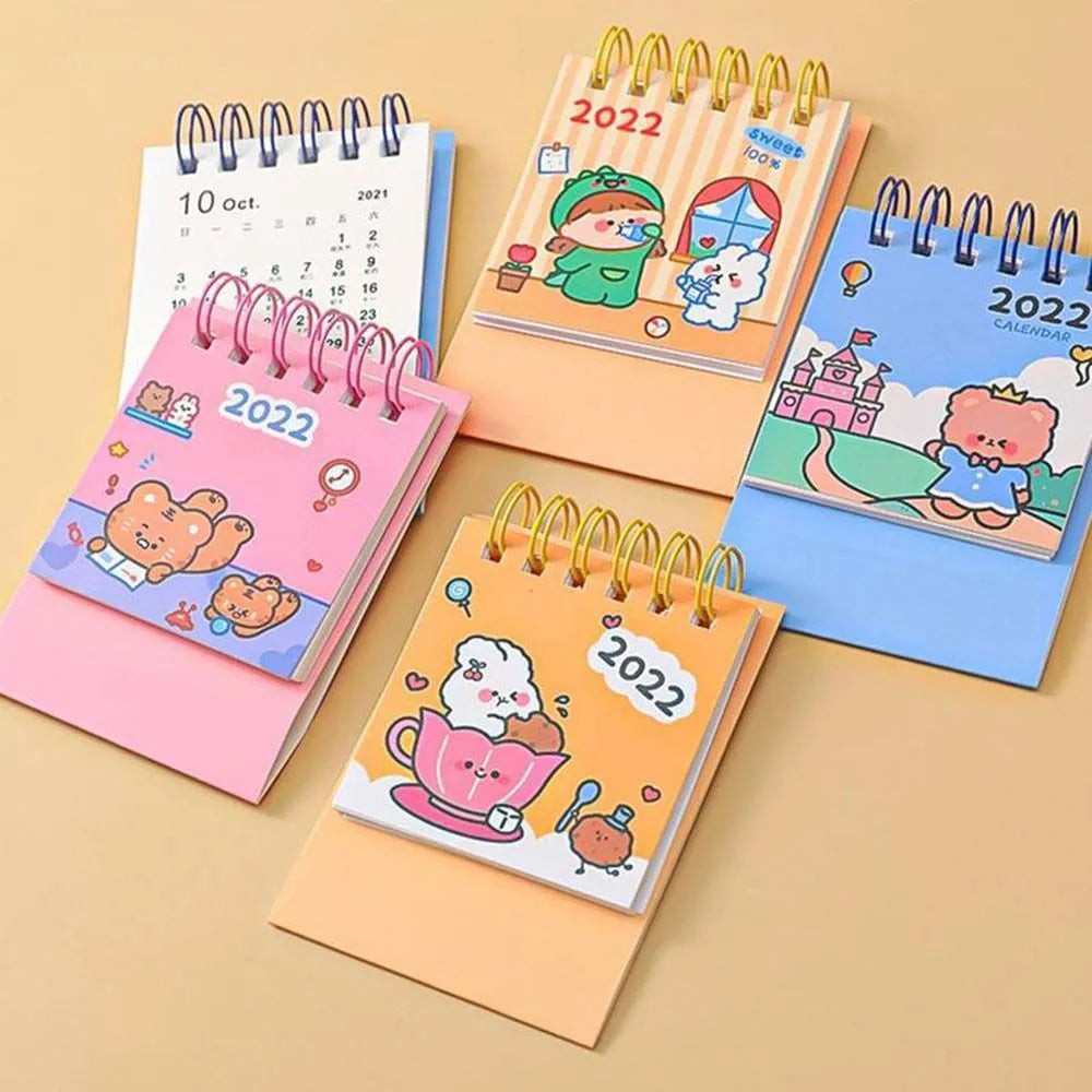 Mini desk calendar with cartoon design showing 9.3cm x 6.4cm paper calendar on a table