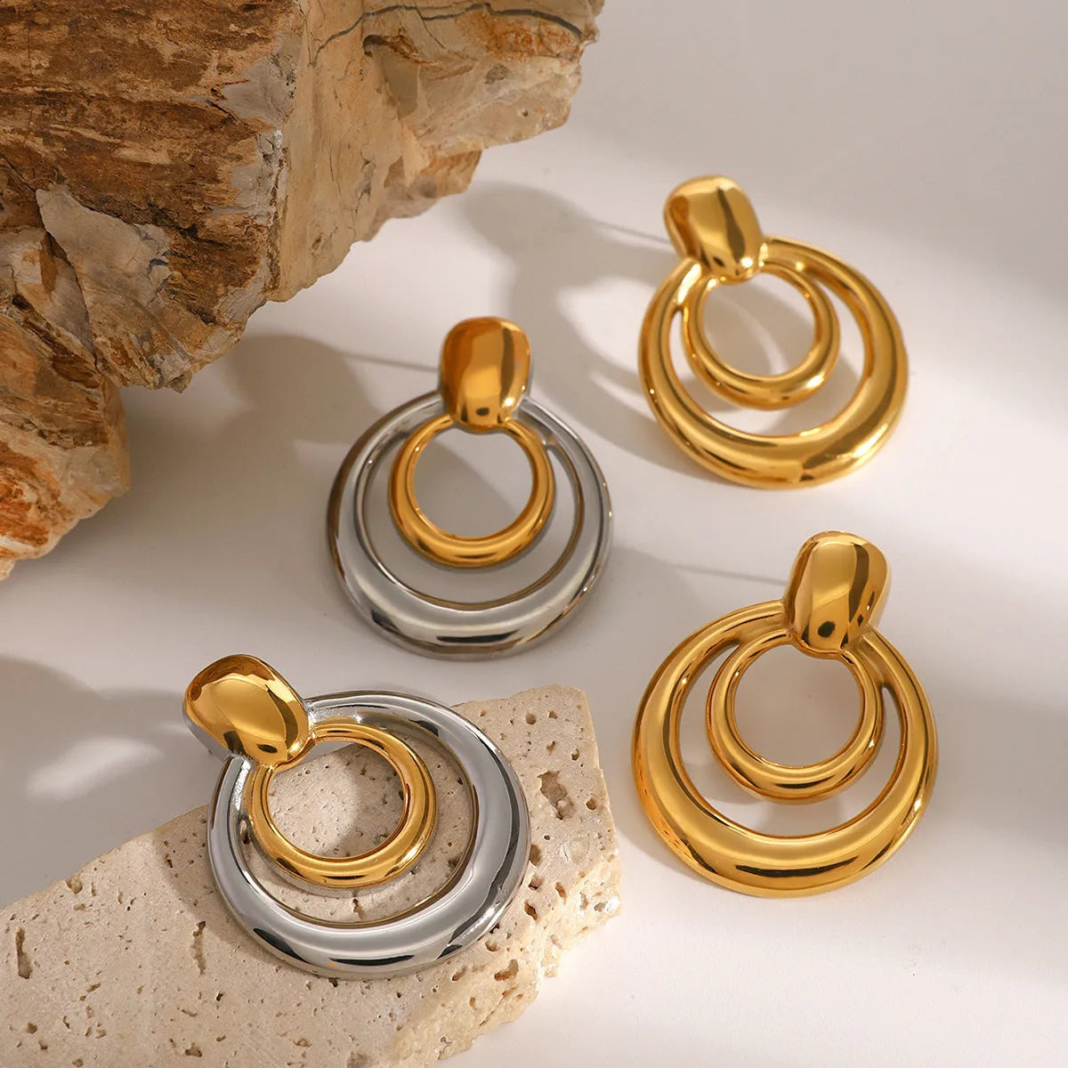 Round double layer hollow stud earrings with 18K gold electroplated finish on titanium steel
