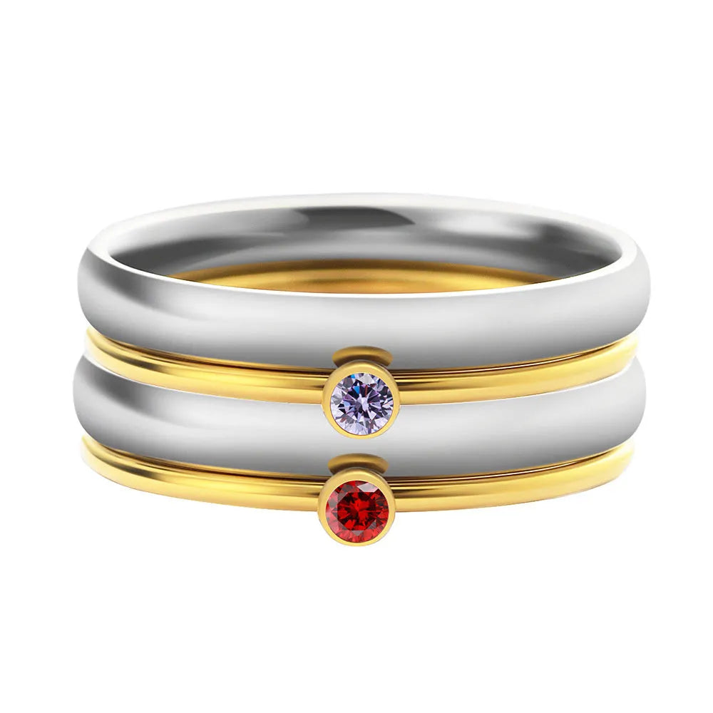 Geometric titanium steel ring with engraved detail and December birthstone colour combination on a finger.