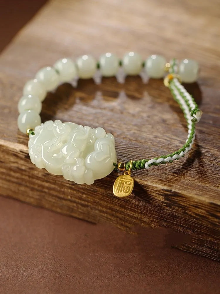 Close-up of a Rabbit zodiac charm Hetian jade bracelet with red rope and S925 silver card.