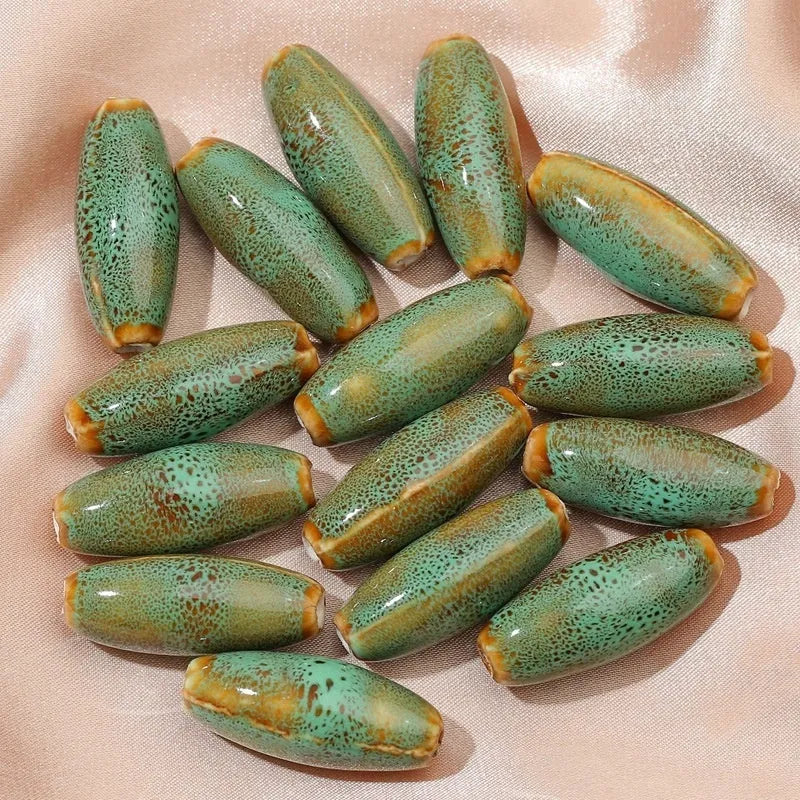 Assorted high-temperature fired ceramic bullet beads in pink, yellow, blue, red, coffee, green, orange, and mixed glaze colours.