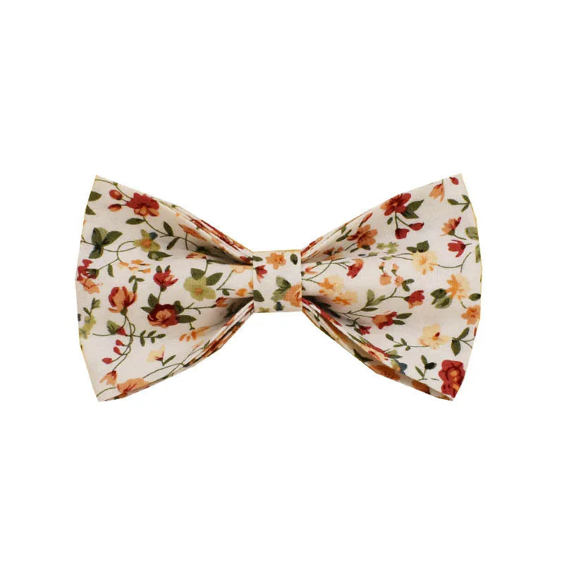 Small white flower pet dog collar set with matching vest, leash, bow, and accessories on a cloth background.