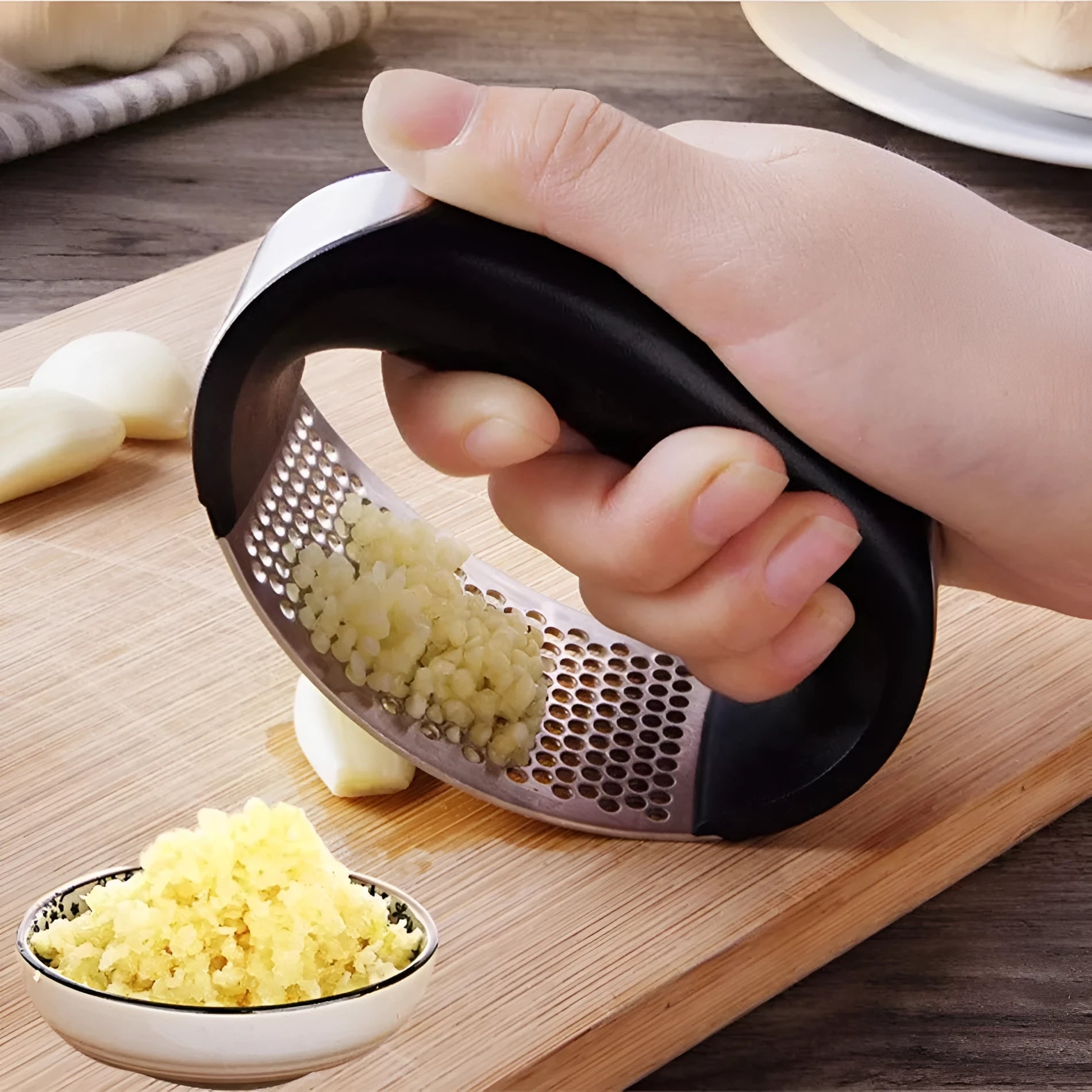 Stainless steel manual garlic press with ergonomic handle in assorted colours