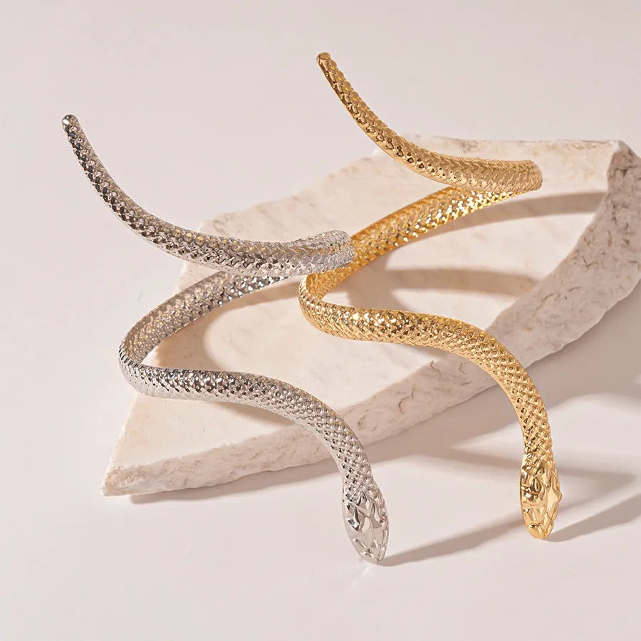 Gold metal snake-inspired ring and bracelet set with exaggerated twisted winding design