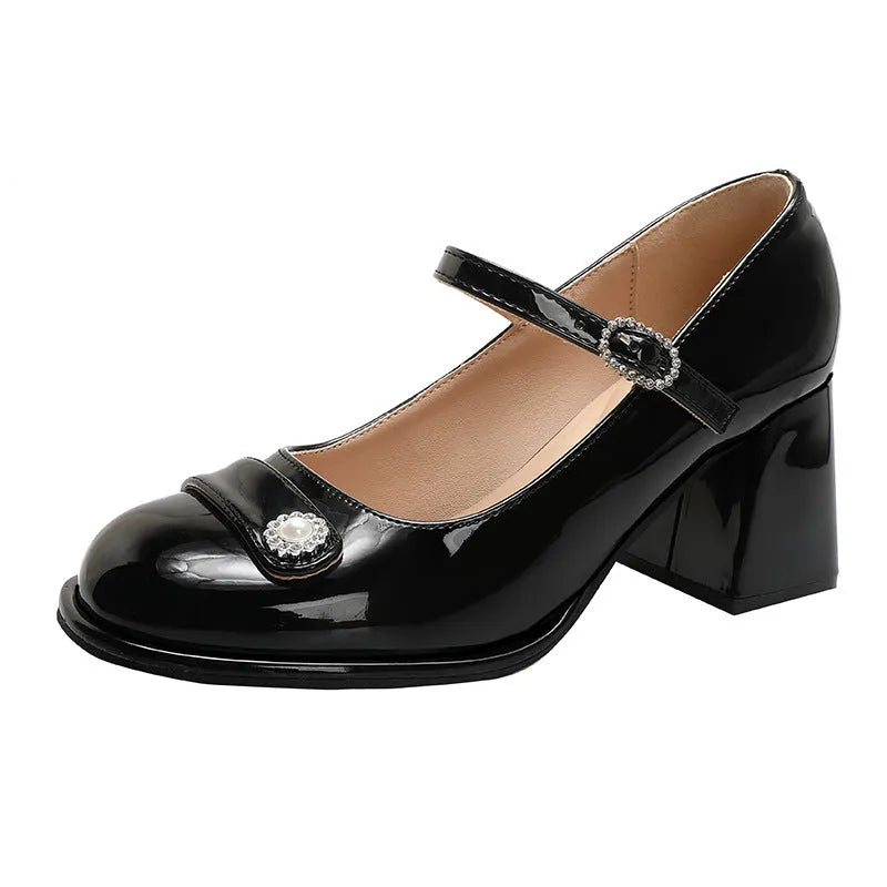 Women's black patent leather wide fit shoes with chunky heel and round toe, showing buckle fastening