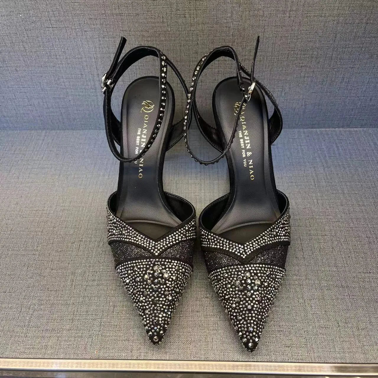 Women's silver hollow high heels with red sole and pointed stiletto heel.