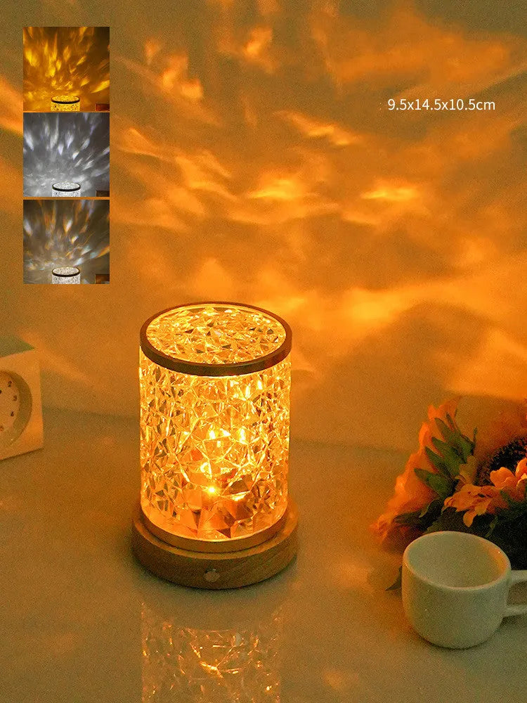 Small rotating water ripple night light with acrylic dome and solid wood base on a table.