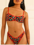 Women's cherry and floral print bikini swimsuit set with tube top and briefs on a neutral background.