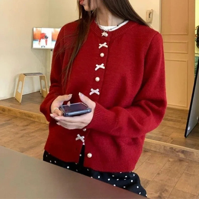 Women's light blue cashmere blend cardigan sweater with a bow and pearl buttons.