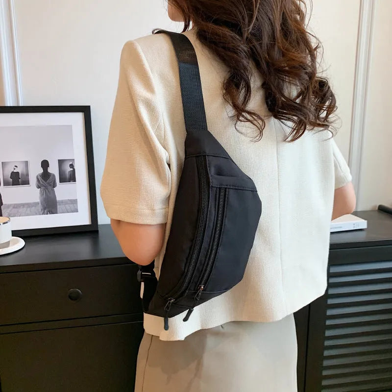 Soft nylon multi-layer mobile phone waist bag with crossbody strap, three-dimensional pocket, and sewing thread detail.