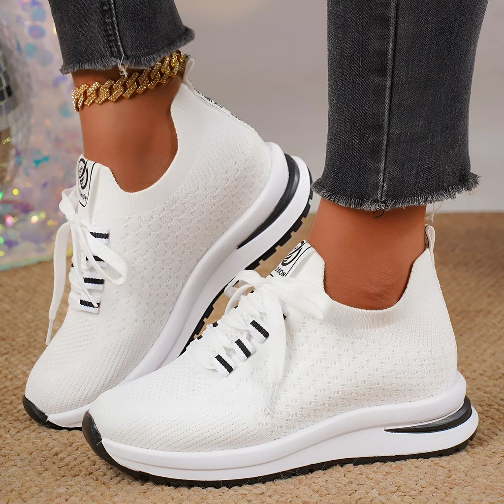 Women's black platform sneakers with mesh upper and lace-up front on flat rubber sole