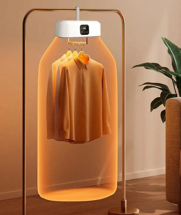 White cylindrical foldable laundry dryer with remote control on a table.