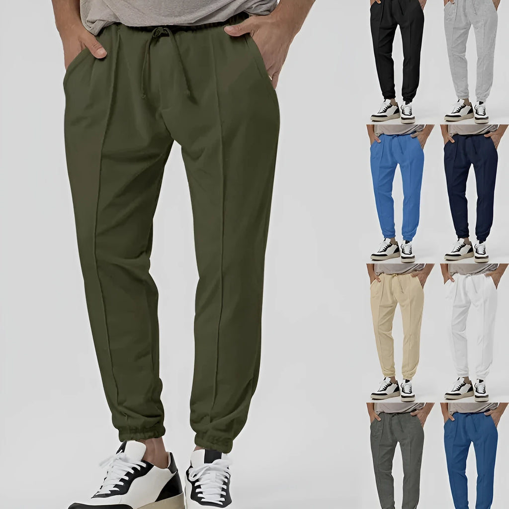 Man wearing grey straight-leg tapered sweatpants, showcasing the mid-rise waist and casual fit.