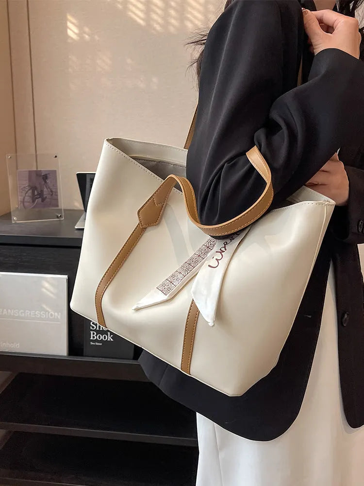 Large soft crossbody tote bag in bucket design showing colour options and internal zipped pocket