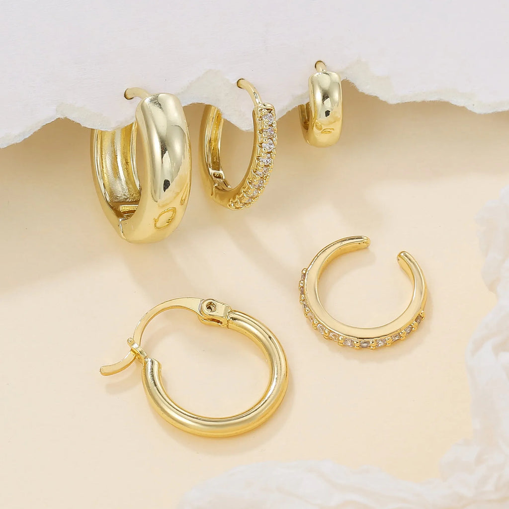 Five round copper earrings with inlaid zircon in gold and white gold colours