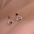 925 silver asymmetrical love earrings with frosty electroplated brown finish on a light background