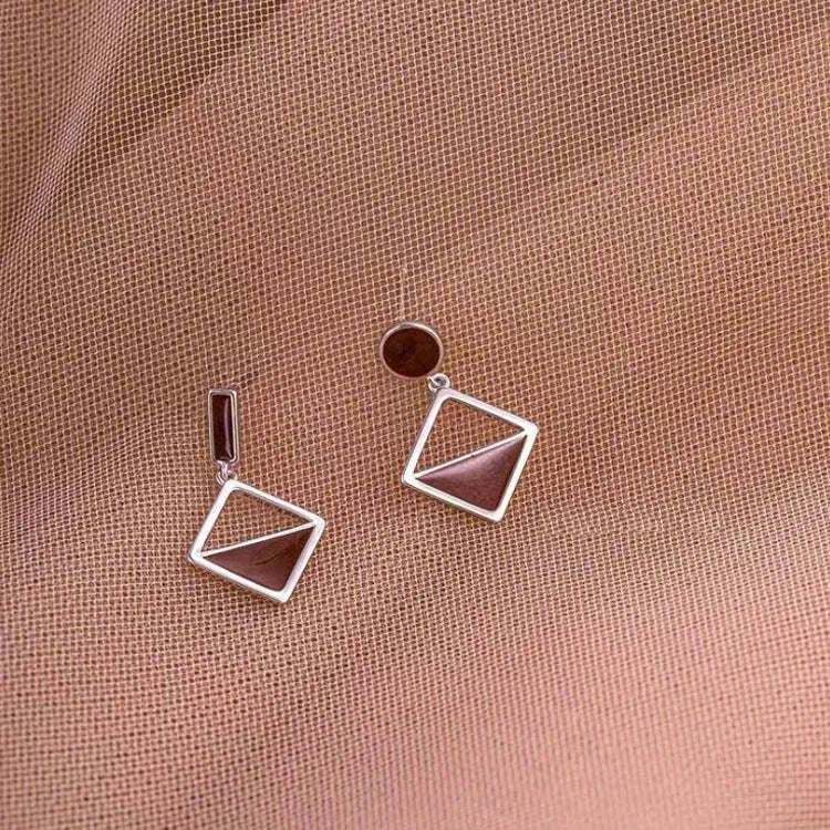 925 silver asymmetrical love earrings with frosty electroplated brown finish on a light background