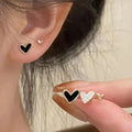 Three pairs of girly heart-shaped alloy earrings in gold, black, pink, and black and white colours.