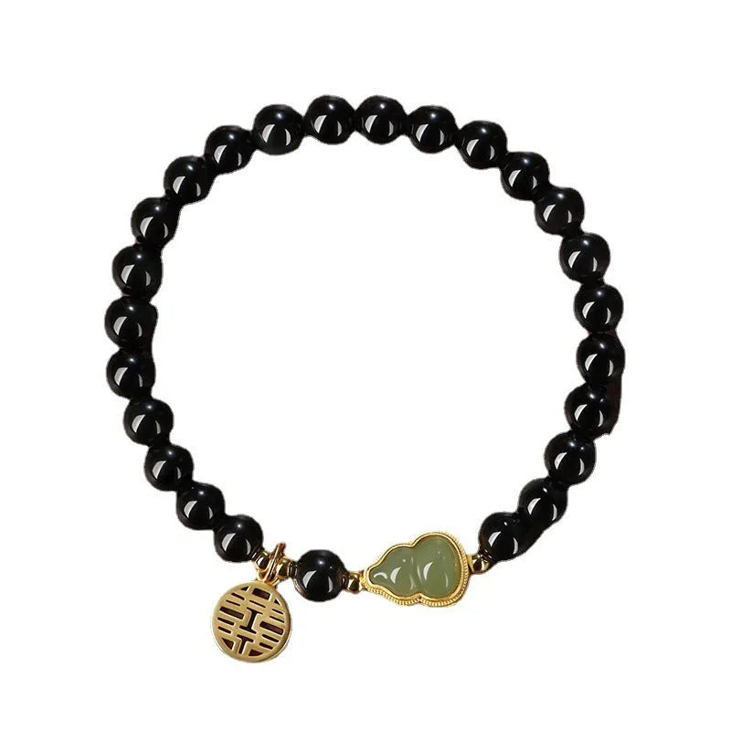 Black obsidian bracelet with a Hetian jade gourd charm, shown in couple style with geometric beads.
