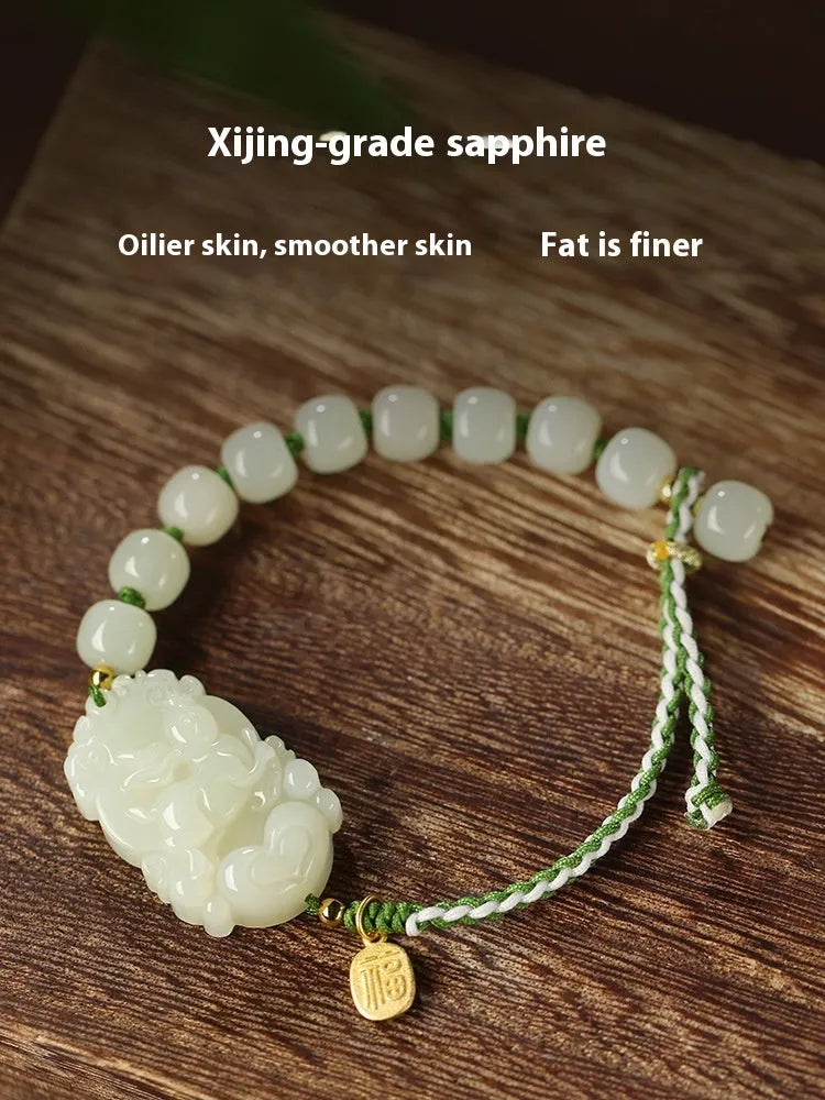 Close-up of a Rabbit zodiac charm Hetian jade bracelet with red rope and S925 silver card.