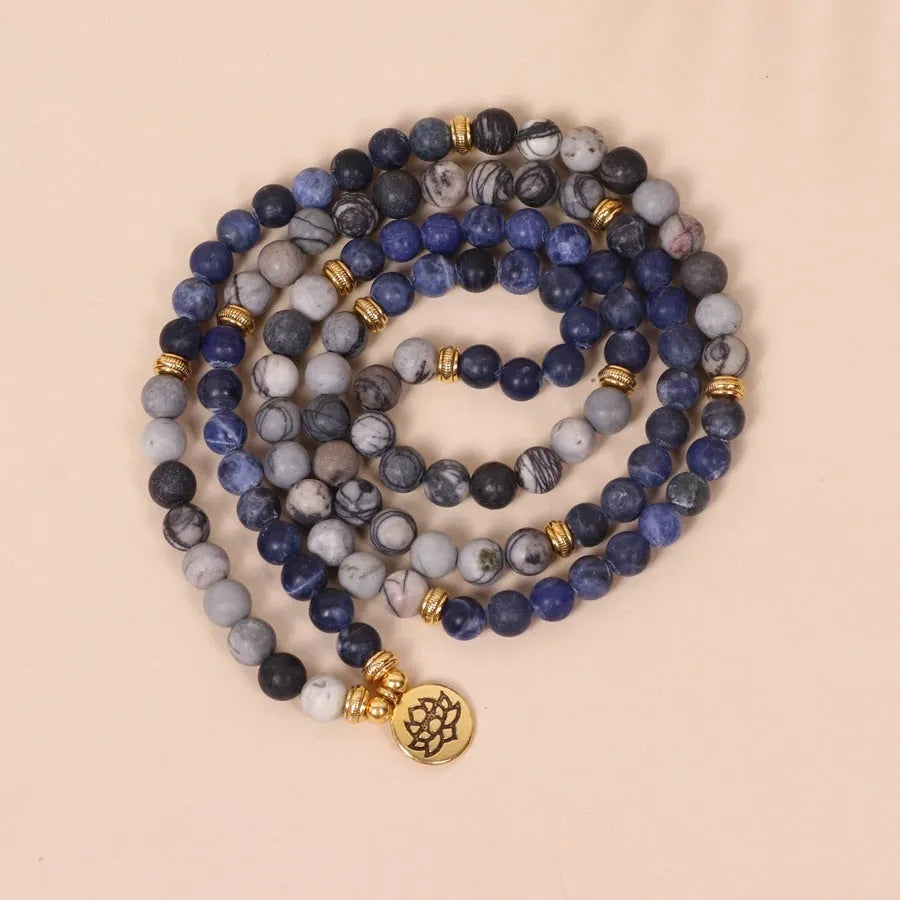 Blue multi-layer bracelet with patterned network stone beads on an alloy base.