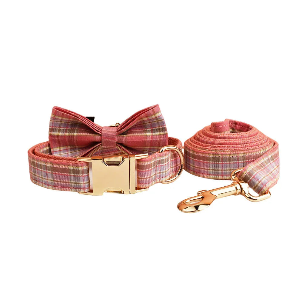 Plaid pattern dog collar and leash set with red bow tie accessory on cloth fabric