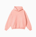 Man wearing a loose-fit cotton terry hooded sweater in a grey apricot colour.