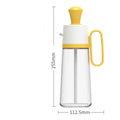 Yellow 2 in 1 oil dispenser with silicone brush next to glass bottle