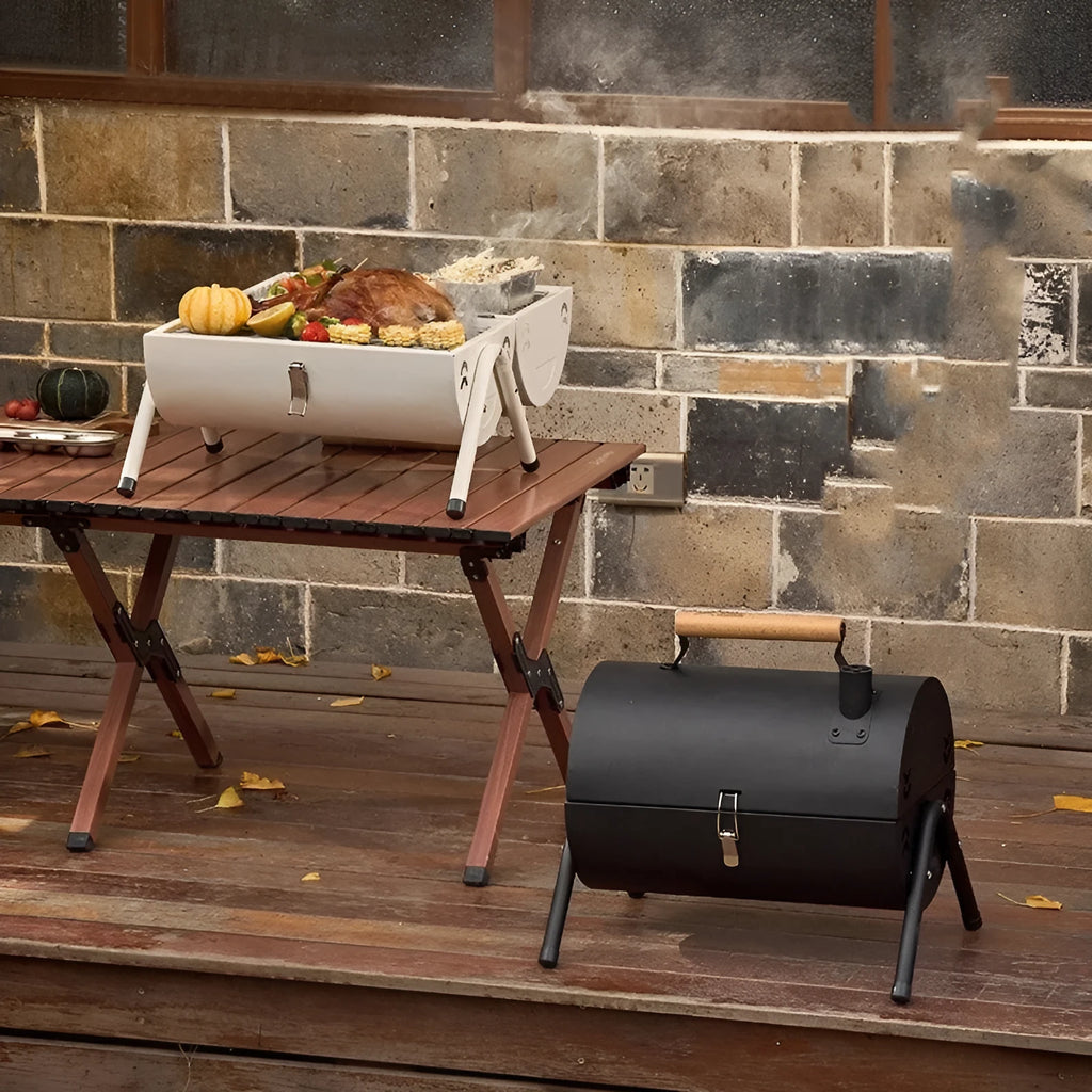 White round portable folding chimney grill with two carbon tanks and mesh grills on grass
