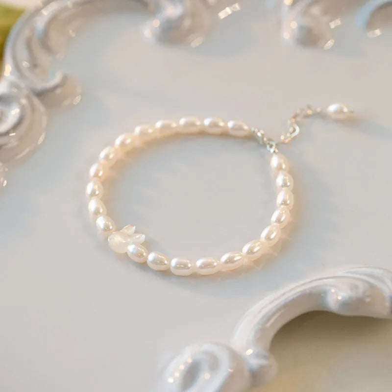 White shell bead bracelet with 925 silver rabbit charm on a black elastic string