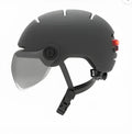 Cycling helmet with built-in red LED tail and brake lights on the rear, shown in M and L sizes.