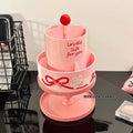 Beige rotating cosmetic brush storage barrel with open lid showing internal organiser rack