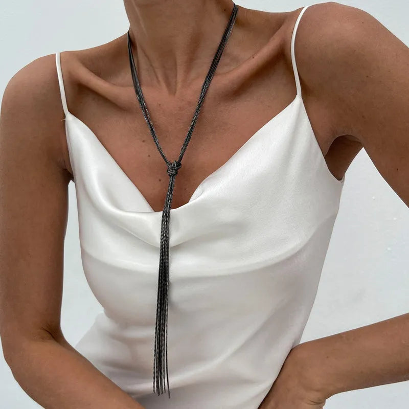 Simple Y-shaped metal tassel necklace set with gold finish and matching earrings on white background
