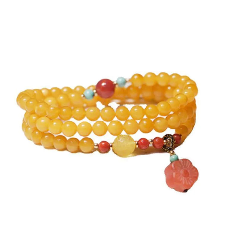 Close-up of a women's amber bracelet with animal modelling on round 5mm beads.
