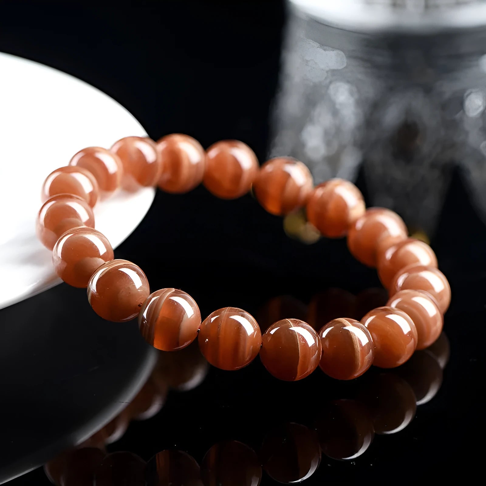 Natural Old Mine Rhodochrosite round bead bracelet with geometric design on wrist.