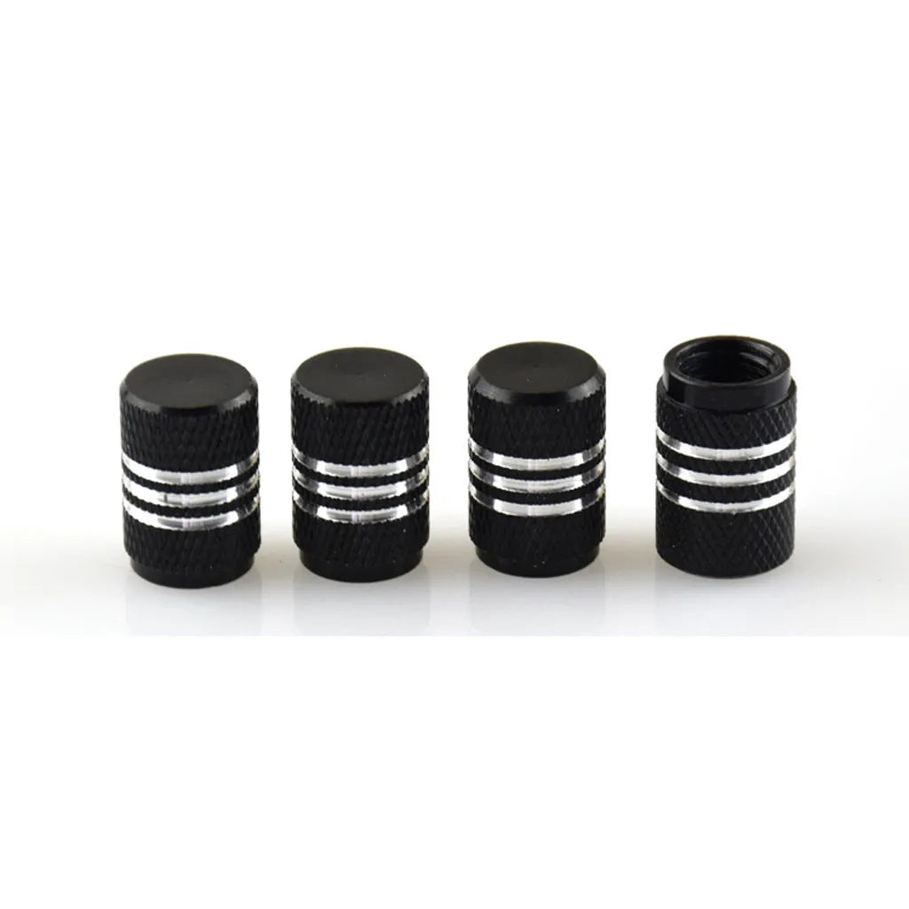 Set of coloured aluminium alloy tyre valve caps for car wheels on a grey background.