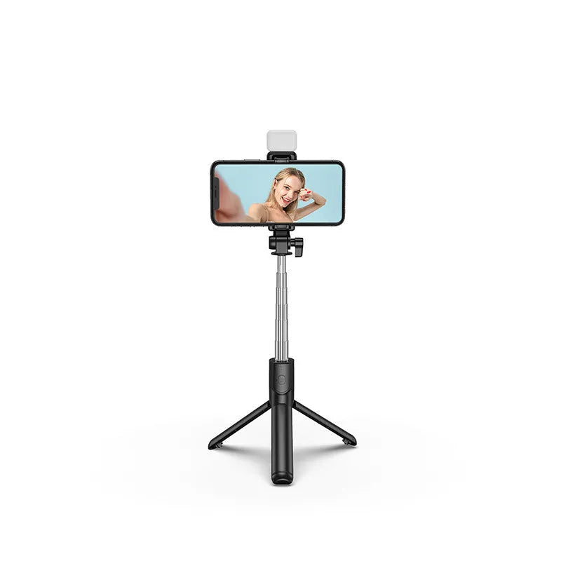 Black Bluetooth selfie stick with extended tripod legs holding an iPhone, showcasing its 360-degree rotating phone holder.
