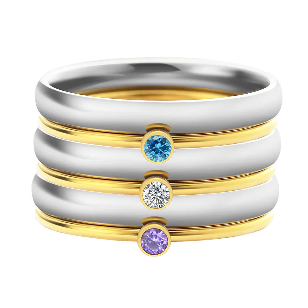 Geometric titanium steel ring with engraved detail and December birthstone colour combination on a finger.
