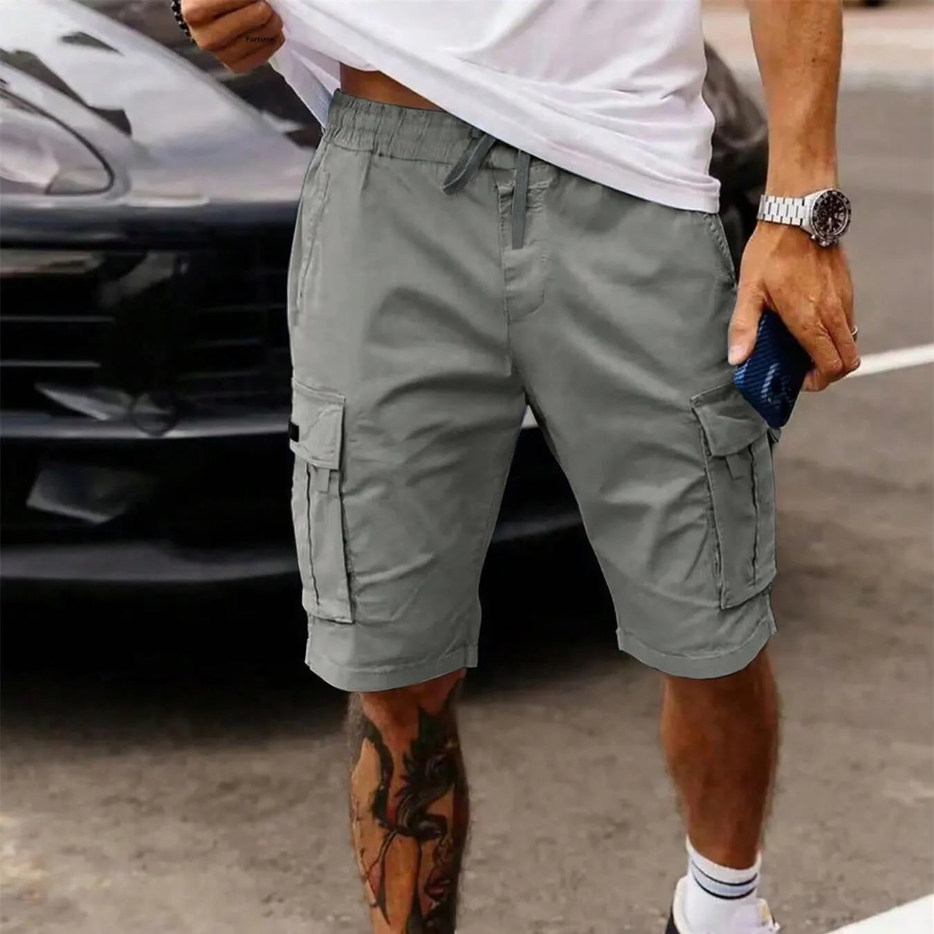 Man wearing loose grey cropped workwear shorts with a straight leg and micro-elastic fabric.