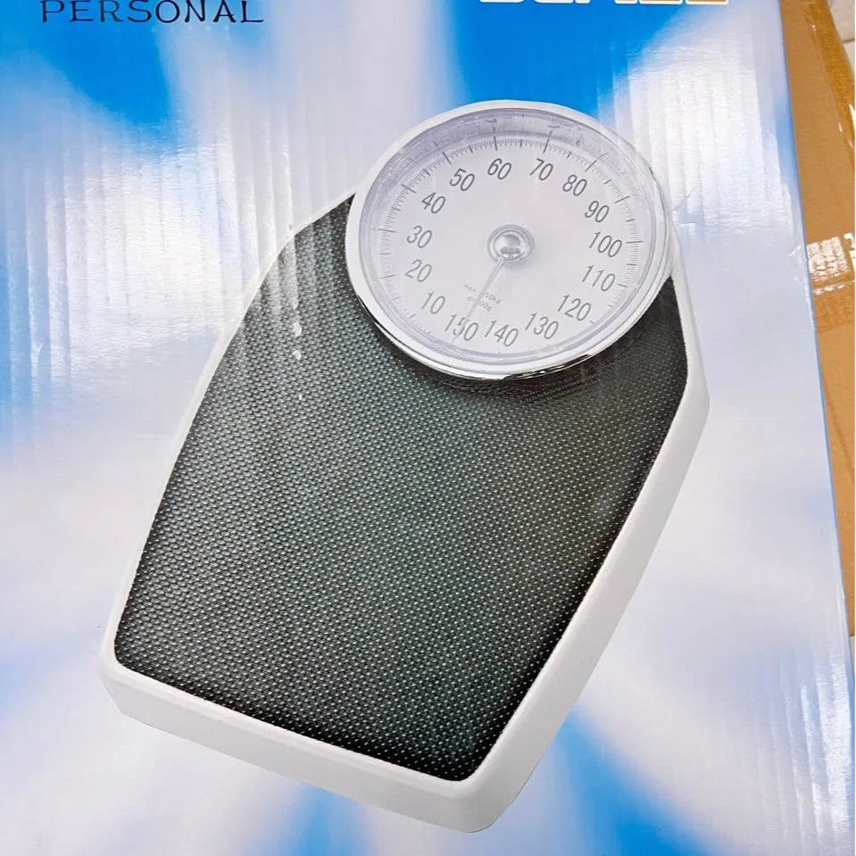 Black mechanical body weight scale with large dial and pointer on a simple platform