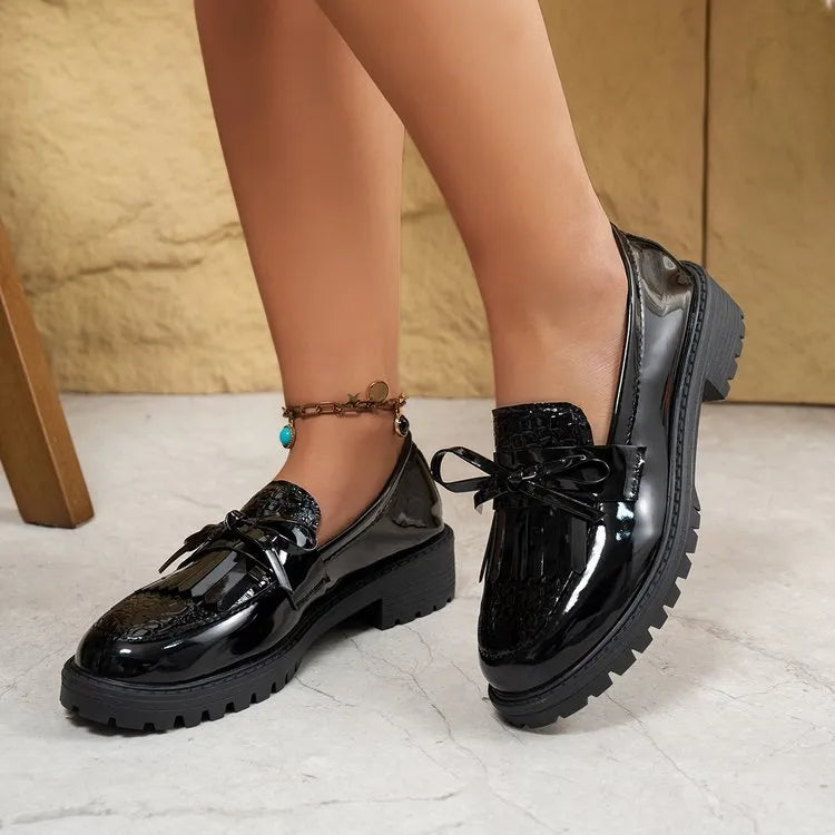 Women's black loafers with a decorative bow detail on the upper.
