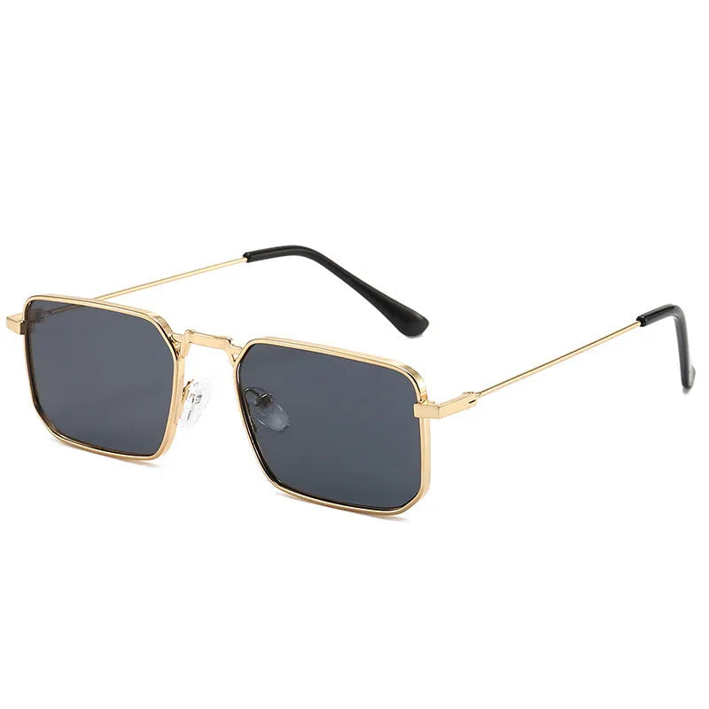 Square-shaped steampunk sunglasses for men with gold frame and grey lenses on a plain background