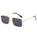Square-shaped steampunk sunglasses for men with gold frame and grey lenses on a plain background
