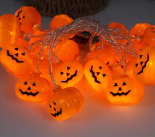 Halloween LED string lights with pumpkin, bat, and ghost decorations hanging on a wall